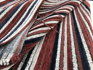Close-up of chenille fabric showing 3D vertical striped texture in red and navy