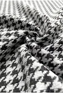 Detailed macro shot of premium black and white houndstooth chenille fabric texture for upholstery