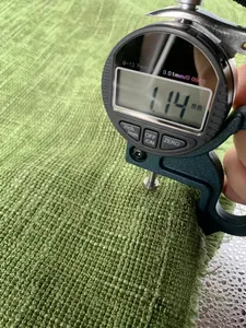 Calibro digitale che misura lo spessore di 1,14 mm del tessuto in ciniglia verde in dettaglio