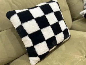 Detailaufnahme eines weichen schwarz-weißen Plüschkissens im Schachbrettmuster