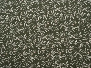 Macro view of vintage botanical chenille jacquard fabric with leaf pattern on green.