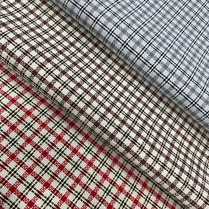 Close-up of three-color plaid polyester fabric showing intricate woven texture.
