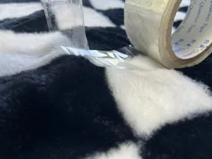 Nahaufnahme von schwarz-weißem Schachbrett-Plüschstoff beim Flusentest