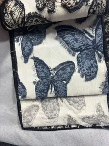 Gros plan sur un tissu jacquard chenille haut de gamme avec des motifs de papillons 3D.