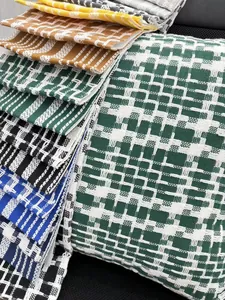 Detailed texture of multi-colored woven cotton linen fabric with geometric lattice patterns.