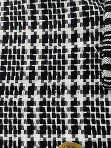 Close-up of black and white woven cotton linen fabric with intricate tweed pattern