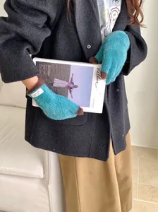 Close-up of soft teal coral fleece gloves with white label detail