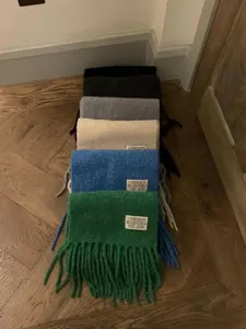 Collection of thick colorful wool scarves with fringes and woven brand label detail