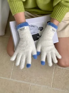 Detail of soft white and blue coral fleece gloves with touchscreen fingertips for winter.