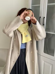 Model draagt een knusse gele gebreide sjaal met ARCLSEE-label in winterkleding