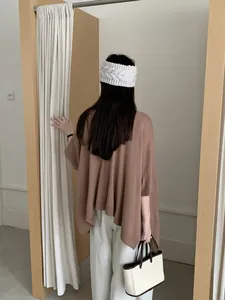 Vista posteriore di una donna che indossa un elegante scialle in maglia retrò marrone.