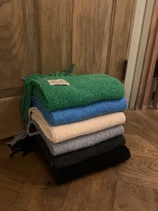 Premium thick wool scarves by UNDERSON stacked in various colors for winter warmth.