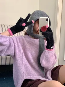 Black coral fleece gloves with pink fuzzy trim and minimalist label detail.