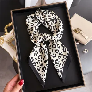 Detailed close-up of a French retro leopard print silk scarf tied as an elegant belt accessory