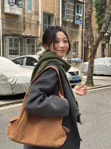 Outdoor lifestyle shot of a woman wearing an olive green Fair Isle scarf