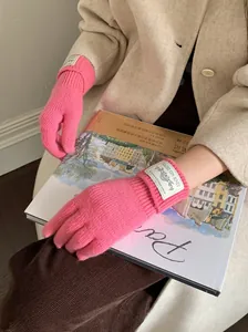 Close-up of pink knitted winter gloves with warm touch-screen design