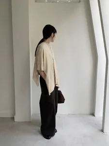 Modella indossa un elegante coprispalle beige in maglia per uno stile autunnale