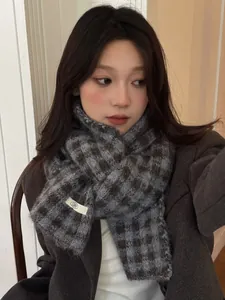 Detailed view of a soft grey and brown checkered knit scarf for winter warmth