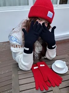 Detailed view of 100% wool touchscreen knitted gloves shown in black and red colors