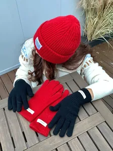 Detail view of 100% merino wool touchscreen knitted gloves in red and black colors.