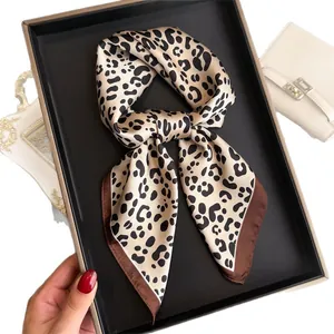 Elegant French vintage leopard print silk square scarf tied in a bow in a gift box