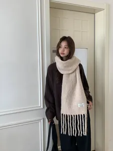 Stylish beige wool fringe scarf worn by a model in a cozy Korean winter look.