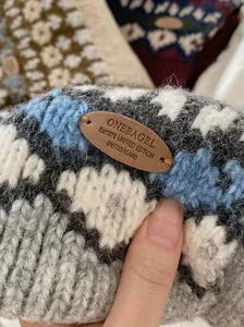 Macro shot of retro Fair Isle knitted scarf texture with premium leather brand label detail