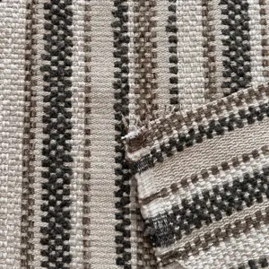 Macro detail of vintage yarn-dyed jacquard fabric featuring earthy striped weaving texture.