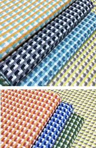 Macro view of fish scale patterned cotton linen jacquard fabric in various colors.