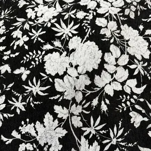 Vista dettagliata dell'elegante motivo floreale bianco e nero su tessuto ciniglia.