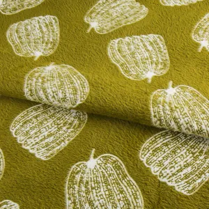 Gros plan de tissu de velours de vison vert moutarde doux avec motifs citrouilles