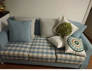 Cotton linen cushion covers with leaf and grid patterns displayed on a blue sofa