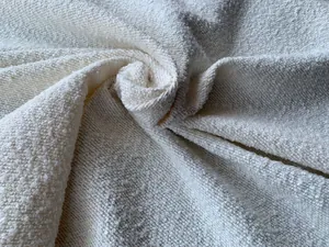 Dettaglio macro di tessuto bouclé in poliestere bianco avorio pesante di alta qualità con trama