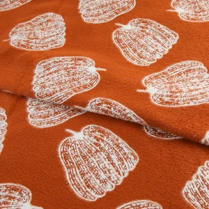 Gros plan sur un tissu en velours de vison orange avec motif de citrouille blanc