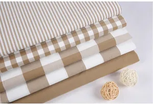 Close-up detail of neutral toned imitation cotton linen fabrics with stripes and checker patterns