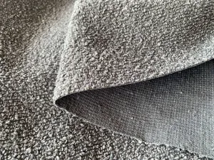 Dettaglio ravvicinato della trama bouclé grigia spessa e del retro in tessuto da tappezzeria