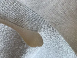 Dettaglio ravvicinato di tessuto bouclé beige e poliestere intrecciato per divani