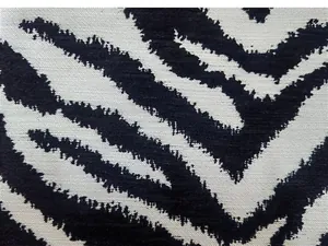 Primo piano dettagliato del tessuto in ciniglia jacquard con motivo zebrato bianco e nero.