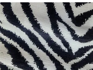 Vista dettagliata del tessuto in ciniglia jacquard con motivo zebrato nero e bianco.