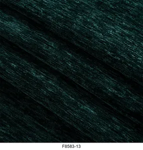 Macro vista dettagliata che mostra la consistenza morbida del tessuto ciniglia verde scuro
