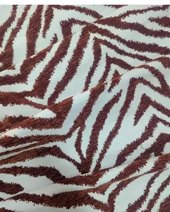 Primo piano di lussuoso tessuto ciniglia jacquard con stampa zebrata marrone per cuscini.
