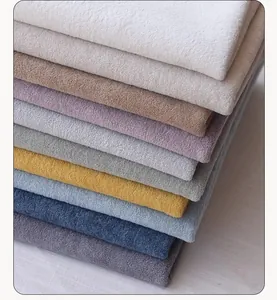 Macro view showing a stack of various colorful thick teddy fleece fabric textures