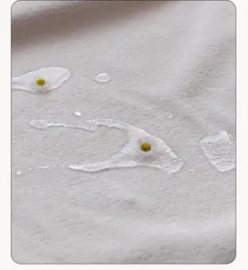 Macro detail view of white water-resistant thick plush fabric featuring clear water droplets