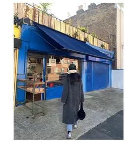 Woman wearing a thick white wool scarf in a stylish outdoor urban street setting
