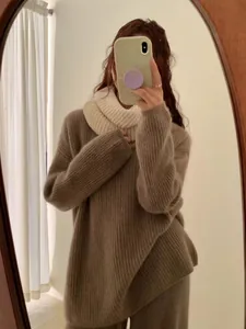 Close-up detail of a cream chunky knit scarf paired with a brown oversized sweater for winter