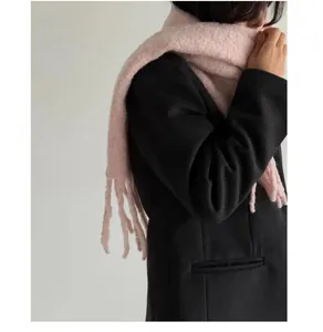 Detail view of a soft pink thickened wool scarf with tassels for winter warmth and style
