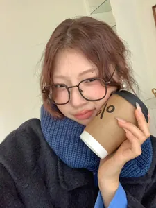 Close-up of a blue knitted neck warmer worn by a model in a cozy winter setting