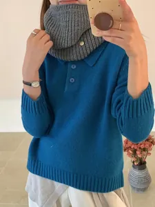 Detailed view of gray chunky ribbed knitted neck warmer with a decorative metal charm
