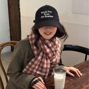 Stylish red and white checkered knit scarf for women shown in a cozy cafe lifestyle setting