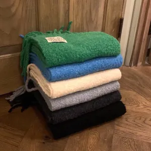 Stacked multi-colored thickened wool scarves with fringe detail and brand label for winter